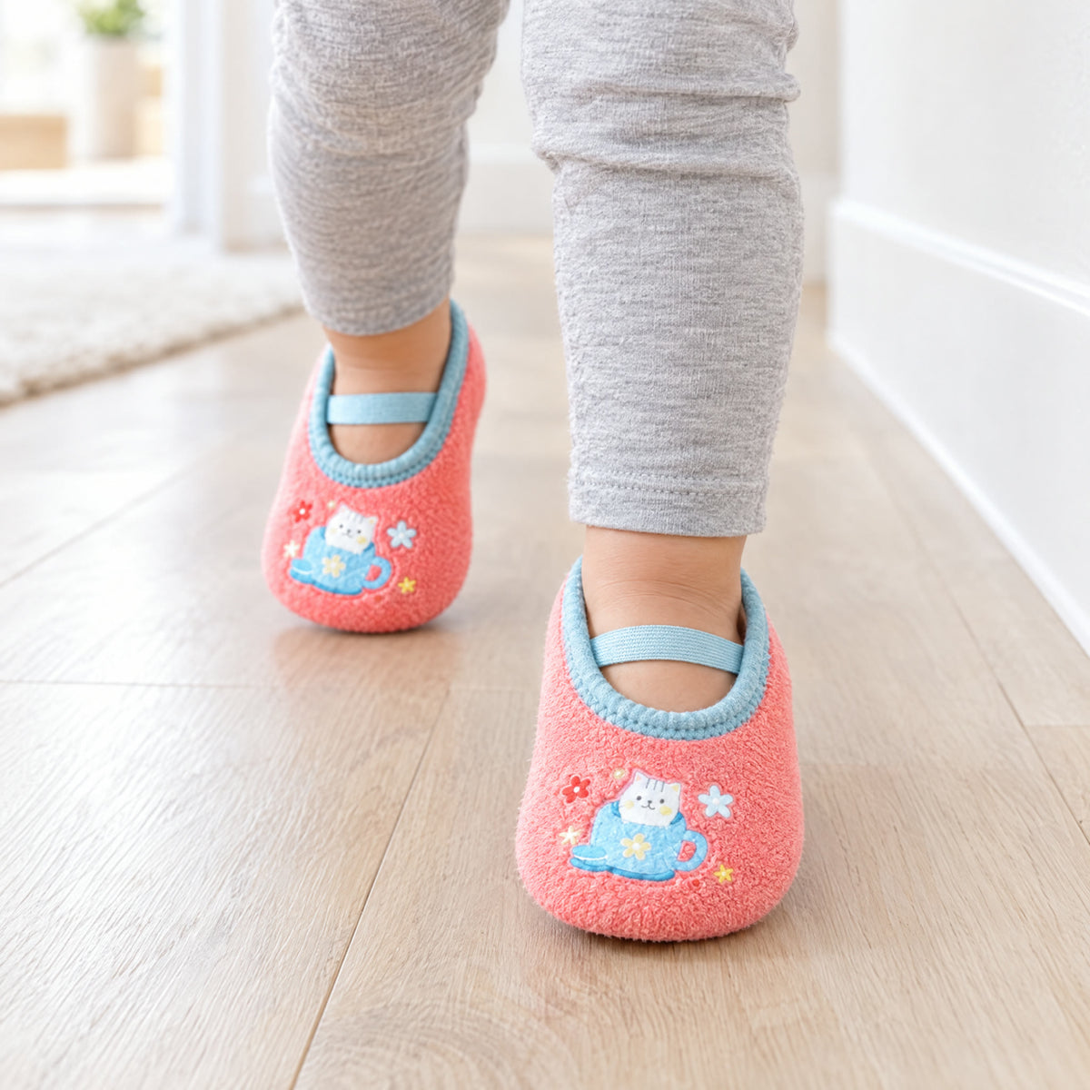 Pink Kitty – a toddler walking down a hallway in Pink Kitty grip socks